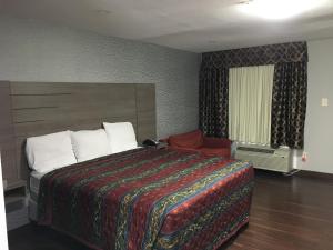Habitación de hotel con cama grande y ventana en Travel Inn & Suites, en Humble