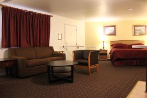 a hotel room with a bed and a couch and a table at Port Townsend Inn in Port Townsend