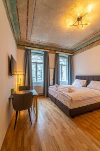 een slaapkamer met een bed, een bureau en ramen bij Agnes I levestate in Wenen