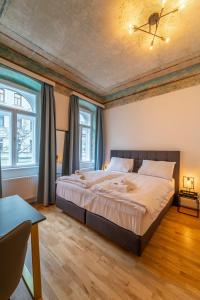 ein Schlafzimmer mit einem großen Bett und zwei Fenstern in der Unterkunft Agnes I levestate in Wien