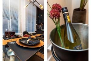 a table with a bottle of wine and a vase of flowers at New Pearl of Scheveningen Black Swan beach a Family loft The Hague in Scheveningen