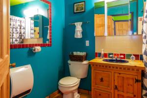 Baño azul con aseo y lavamanos en Chuck's Cabin in a Joshua Tree Community, en Twentynine Palms