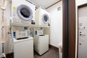 een wasruimte met 2 magnetrons en een wasmachine en droger bij Hotel Hana in Takayama