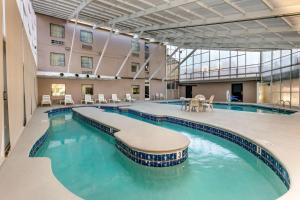 una gran piscina en un edificio con sillas y mesas en Sleep Inn & Suites near Sports World Blvd, en Gatlinburg