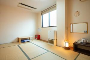 een lege kamer met een koelkast en een raam bij Hotel Hana in Takayama