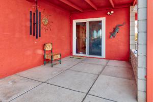 a red room with a chair and a door at Chuck's Cabin in a Joshua Tree Community in Twentynine Palms