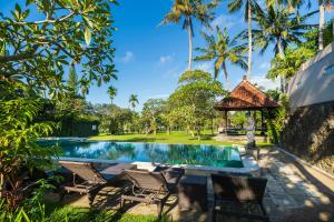 una piscina con sillas y un cenador en Amatara Agung Raka, en Ubud
