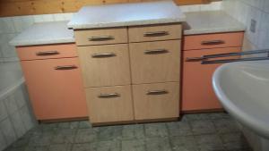 a bathroom with a sink and a counter with cabinets at Ferienhaus Schwörer in Rheinhausen +20 photos