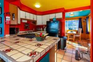 eine Küche mit roten und gelben Wänden und einer Arbeitsplatte in der Unterkunft Chuck's Cabin in a Joshua Tree Community in Twentynine Palms
