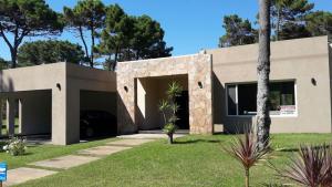 una casa con garaje en un patio en Excelente casa Pinamar Norte con piscina 6 personas, en Pinamar