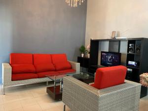 a living room with a red couch and chairs at Pak Lang Homestay in Kampung Gurun