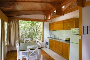 a kitchen with wooden cabinets and a table and chairs at Beauty Point Tourist Park in Beauty Point