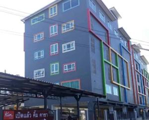 wysoki budynek z kolorowymi oknami w obiekcie Kim Casa w mieście Nakhon Sawan