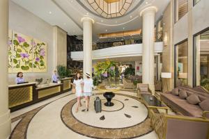 two people standing in the lobby of a hotel at Holiday Beach Hotel Danang in Danang +142 photos