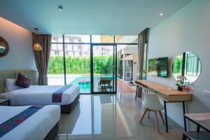 Habitación de hotel con 2 camas, escritorio y piscina en Good Night Pool Villa Phuket - SHA Plus, en Phuket