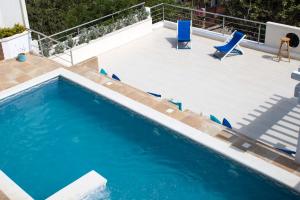 a swimming pool with blue chairs and a patio at Techos Azules in Taganga