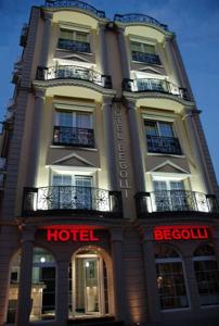 ein Hotelgebäude mit einem Schild davor in der Unterkunft Hotel Begolli in Pristina