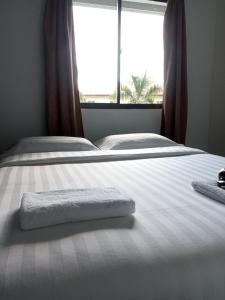 a bed with two towels on it with a window at TEMPO in Semporna
