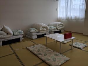 Zimmer mit 2 Sofas, einem Tisch und einem Sofa in der Unterkunft 街のホテル in Fujiyoshida