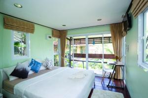 a bedroom with a large white bed and a window at Hill Zone Home Stay by Little Paradise in Haad Rin