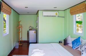1 dormitorio con cama blanca y paredes verdes en Hill Zone Home Stay by Little Paradise en Haad Rin