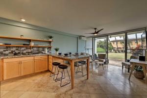 a kitchen with a table and chairs in a room at Condo with Lanai at Beginning of Road to Hana! in Paia