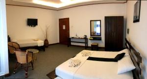 a hotel room with two beds and a desk at Nico Lagoon Hotel in Negombo