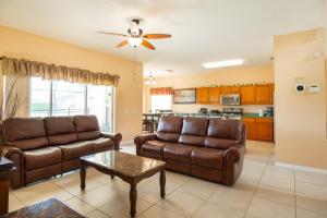 a living room with two brown leather couches and a table at Sweet Memories in Kissimmee