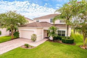 a house with a garage and palm trees at Sweet Memories in Kissimmee