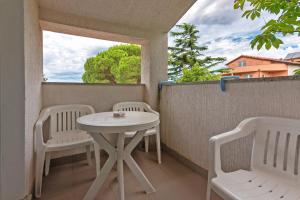 a small white table and two chairs on a balcony at Liliana in Medulin * Istrien in Medulin