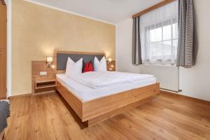 a bedroom with a bed with white sheets and red pillows at Haus Kirchner in Flachau