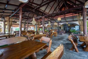 un restaurante con mesas de madera y sillas en una habitación en Nice Beach Resort Koh Pha-ngan en Thong Nai Pan Yai