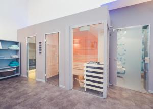 La salle de bains est pourvue de portes coulissantes en verre et d'un lavabo. dans l'établissement Alexianer Hotel am Wasserturm, à Münster