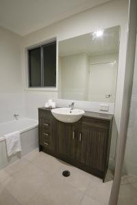 a bathroom with a sink and a mirror at Direct Hotels - Breeze on Brightwater in Mooloolaba