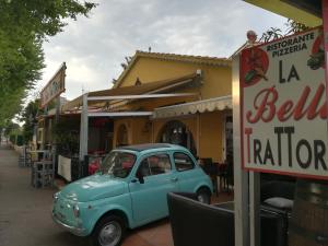 un viejo coche azul estacionado frente a un restaurante en Atoll Hotel restaurant en Fréjus