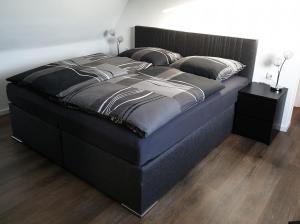 - un grand lit avec un cadre noir dans la chambre dans l'établissement Ferienwohnung Berger Bocholt, à Bocholt