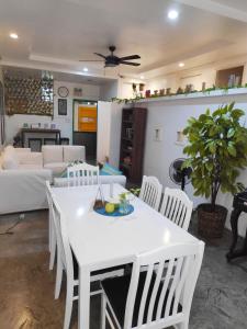 a living room with a white table and white chairs at Crossroads Hostel Manila in Manila