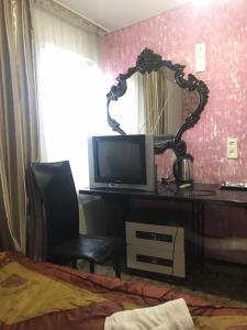 a bedroom with a desk with a television and a mirror at Central Studio Blum in Chişinău