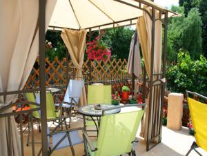 a patio with a table and chairs under an umbrella at Flower's in Bucharest