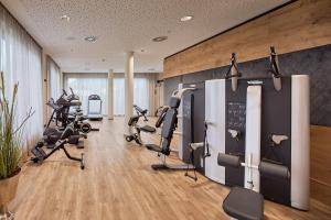 einen Fitnessraum mit mehreren Laufbändern und Kardiogeräten in der Unterkunft Laschenskyhof Hotel & Spa in Wals