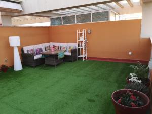 a room with a green floor with chairs and a table at Spectacular views. All new with free parking in Córdoba