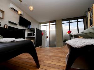uma sala de estar com pisos em madeira e uma grande janela em Appartement spa privatif Grenoble At Home Spa em Grenoble