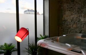 La salle de bains est pourvue d'une lumière rouge et d'une baignoire. dans l'établissement Appartement spa privatif Grenoble At Home Spa, à Grenoble