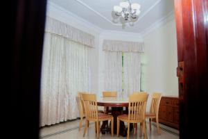 a dining room with a table and chairs and a chandelier at Luxury Apartment with Ocean View in Oyster Bay in Dar es Salaam