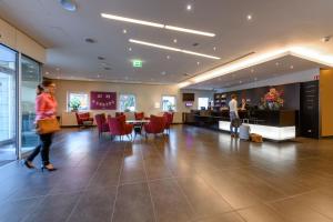 a lobby with people walking around in a building at Mercure Stuttgart City Center in Stuttgart