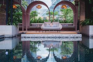 un vestíbulo de hotel con piscina frente a un edificio en KLoe Hotel en Kuala Lumpur