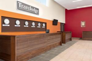 una sala de espera con relojes en la pared en Travelodge by Wyndham Richmond Hill, en Richmond Hill