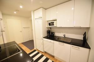 eine Küche mit weißen Schränken und einem Waschbecken in der Unterkunft Rental Apartment Lonttinen Suomen Vuokramajoitus Oy in Turku