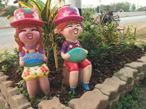 two figurines of girls wearing fire helmets in a garden at Ingkho Khao Kho อิงค้อ เขาค้อ in Khao Kho