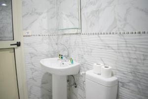 La salle de bains blanche est pourvue d'un lavabo et de toilettes. dans l'établissement Golden Palace Hotel, au Caire